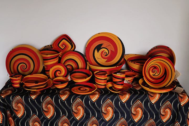 Collection of Sunset Zulu wire baskets handwoven in South Africa in warm red, orange, golden yellow and black spiral patterns.