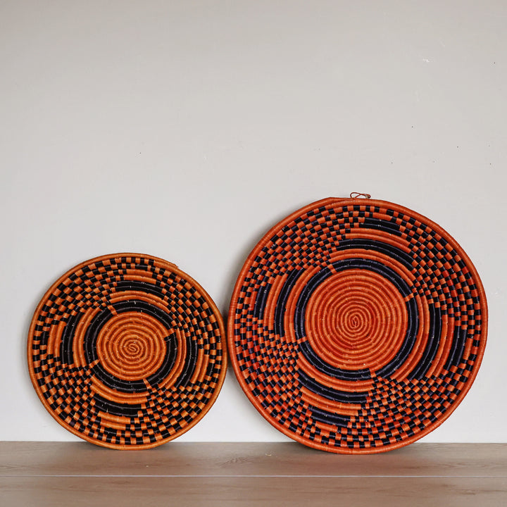 Handwoven Sunstone Check Bukedo and Raffia bowl handmade in Uganda featuring a bold black and orange checkerboard design for fair trade home décor.