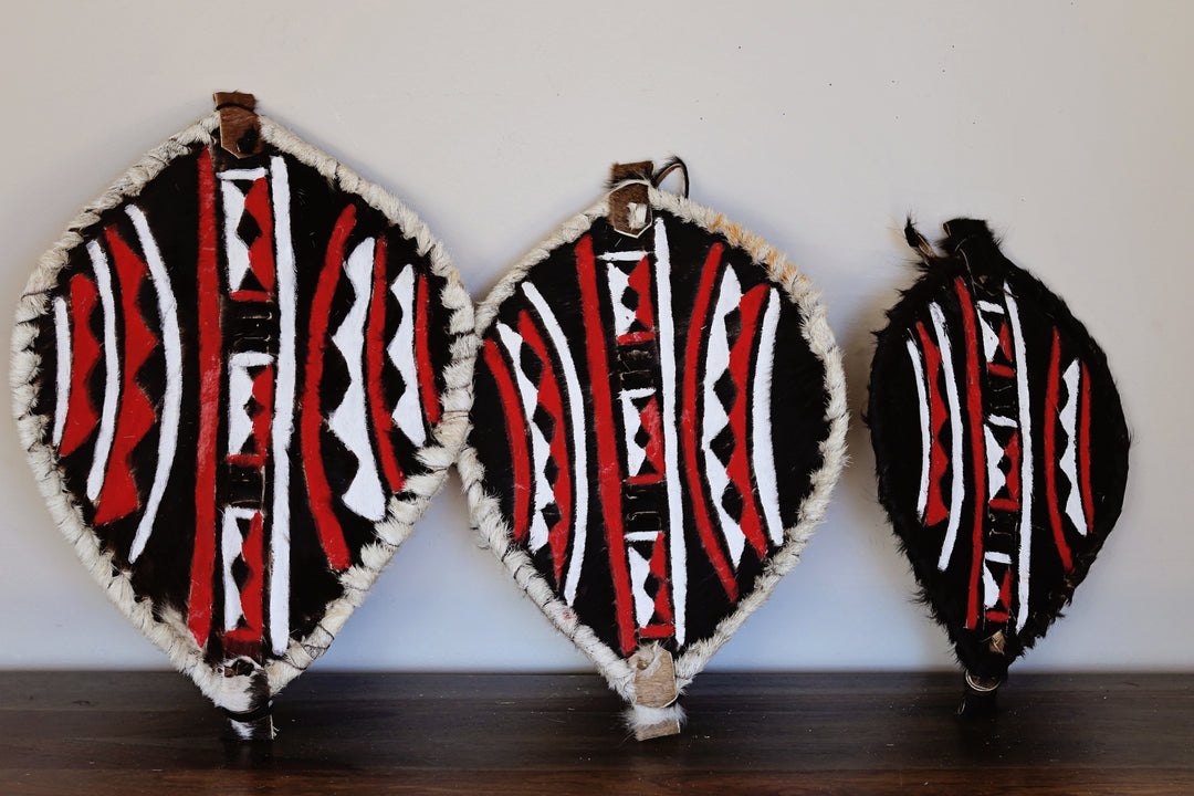 Three sizes of our fair-trade African leather shield handmade in Kenya with hand painted tribal design.