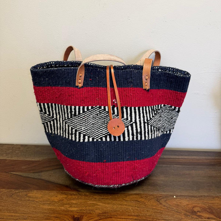 Woven bag with red, black, and white stripes and leather short handles. Button closure front makes sure everything is secure. 