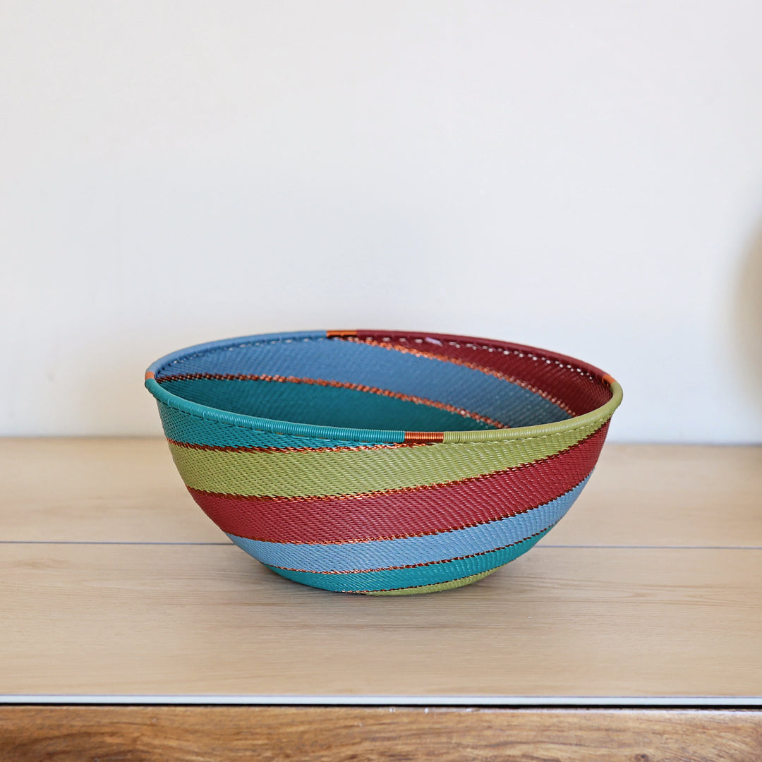 Tidepool Zulu Extra Large Bowl handwoven in South Africa with teal, deep green, and warm red in a diagonal stripe pattern.