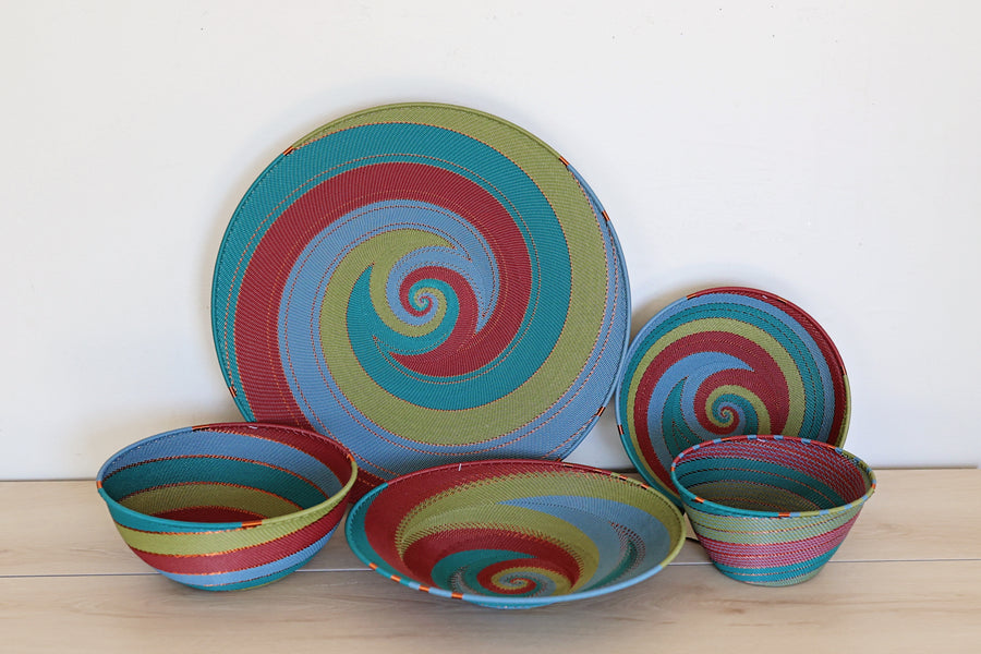 Collection of the Tidepool Zulu Baskets featuring intricate handwoven wire craftsmanship in vibrant teal, green, and red tones.