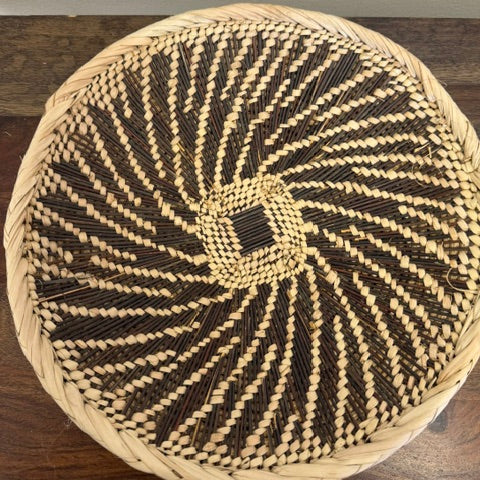 Assorted Tonga flat basket bowls from Zambia with unique handmade patterns and natural dye tones