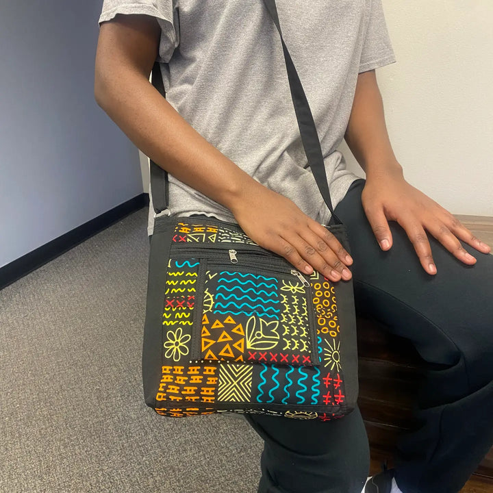 Unisex recycled fabric crossbody travel bag worn across body, made in Kenya.
