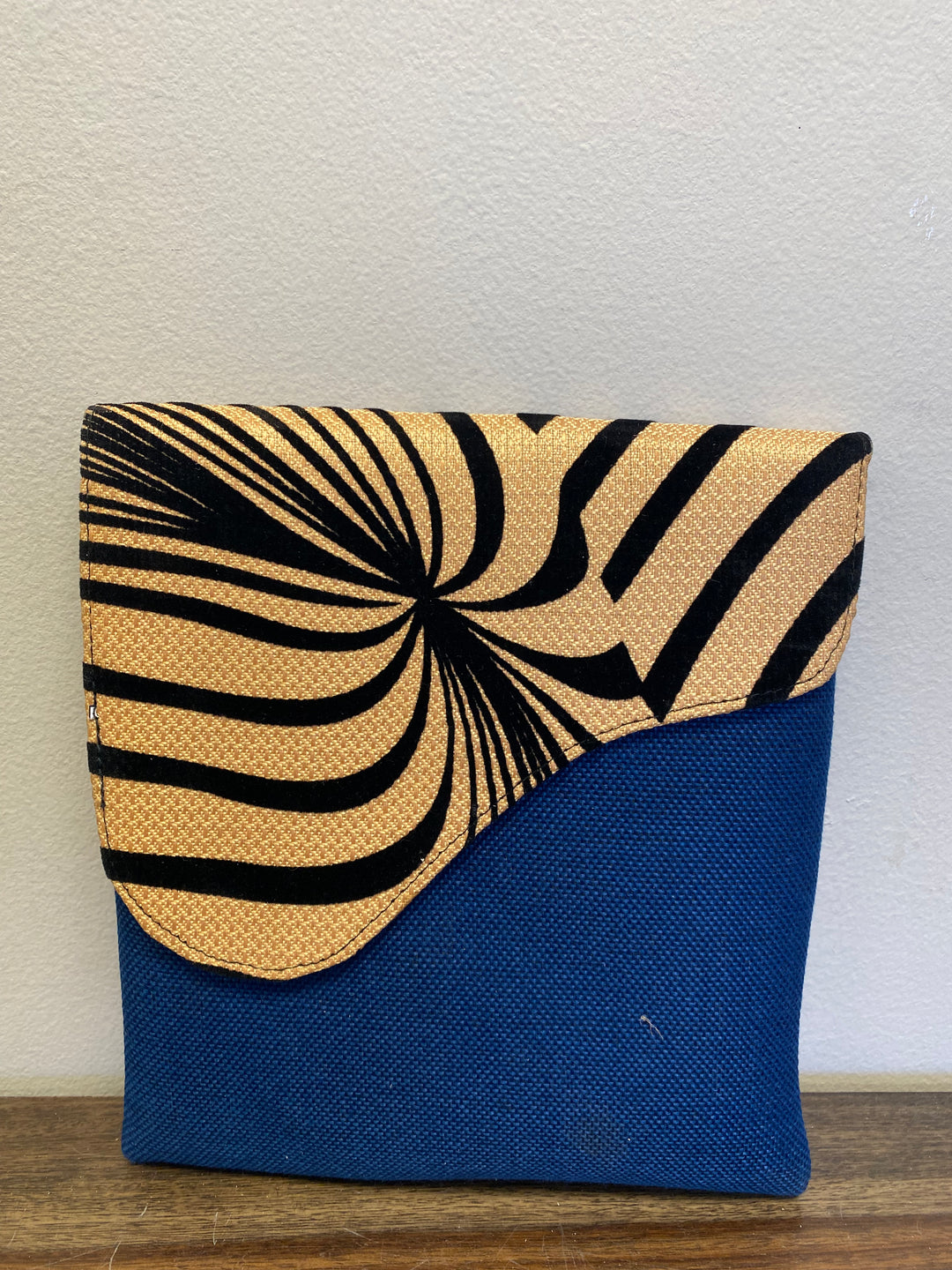 Blue crossbody bag with a zebra printed flap.