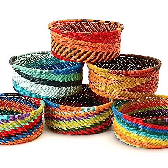 A set of six hand-woven Zulu baskets in various sizes, each decorated with vibrant, multicolored horizontal stripes including red, orange, yellow, green, blue, purple, and black.